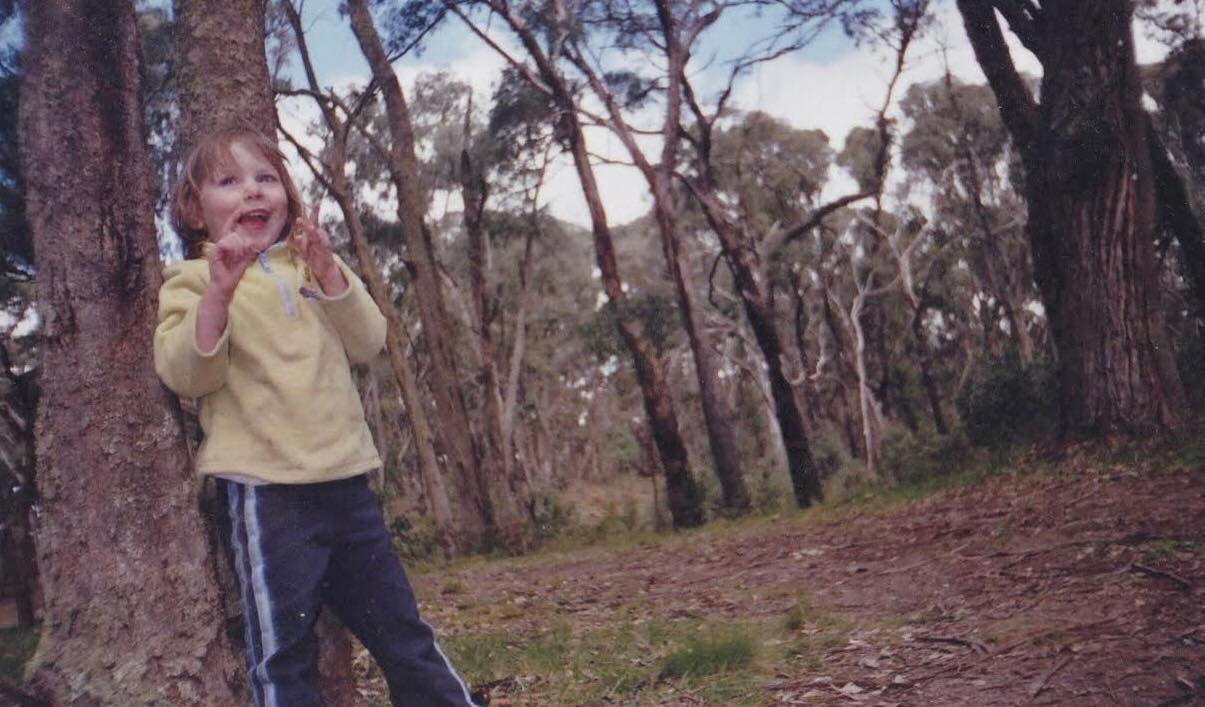 Julia Hunt, pictured as a child, standing in bushland.