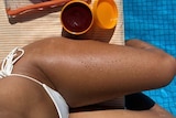 An Instagram post showing an image of a woman wearing a bikini with tanned legs next to a container of gel.