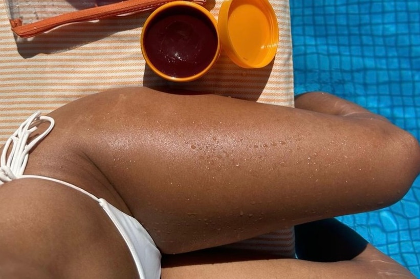 An Instagram post showing an image of a woman wearing a bikini with tanned legs next to a container of gel.