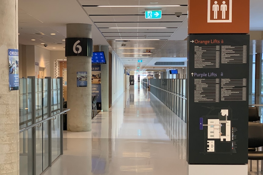 An interior shot of the hospital, showing the shiny floors & wide use of glass plus a white bollard against the white floors