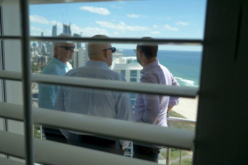 Jason McFetridge, Austin Whittaker and Mark Willacy on a balcony overlooking the Gold Coast.