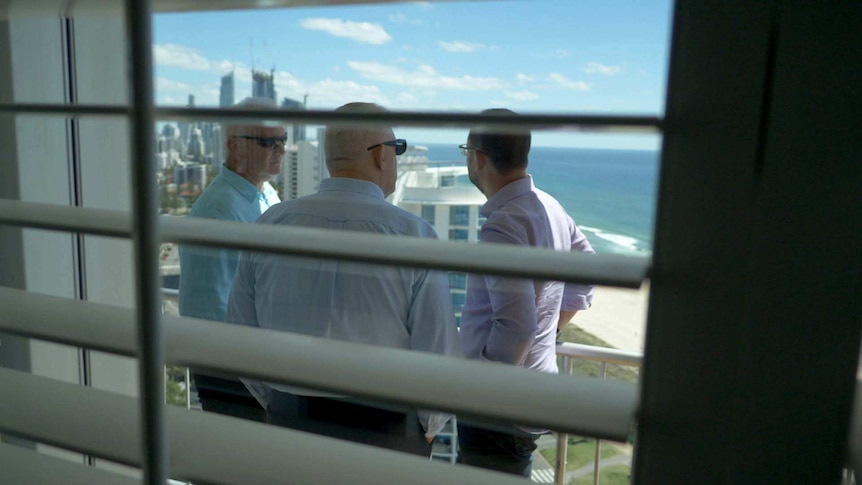 Jason McFetridge, Austin Whittaker and Mark Willacy on a balcony overlooking the Gold Coast.