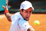 Novak Djokovic returns at the French Open.