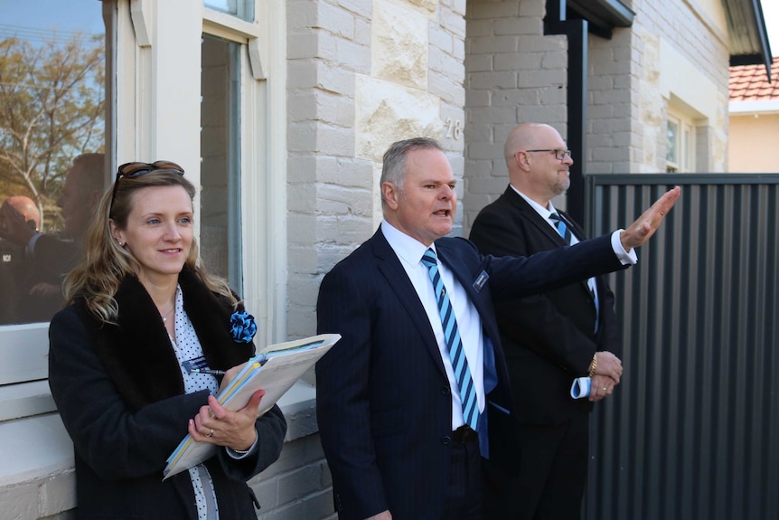 An auctioneer and his helpers auctioning a house auction