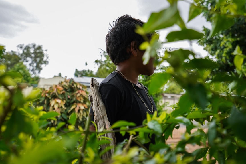 Boy standing in bush with face obscured