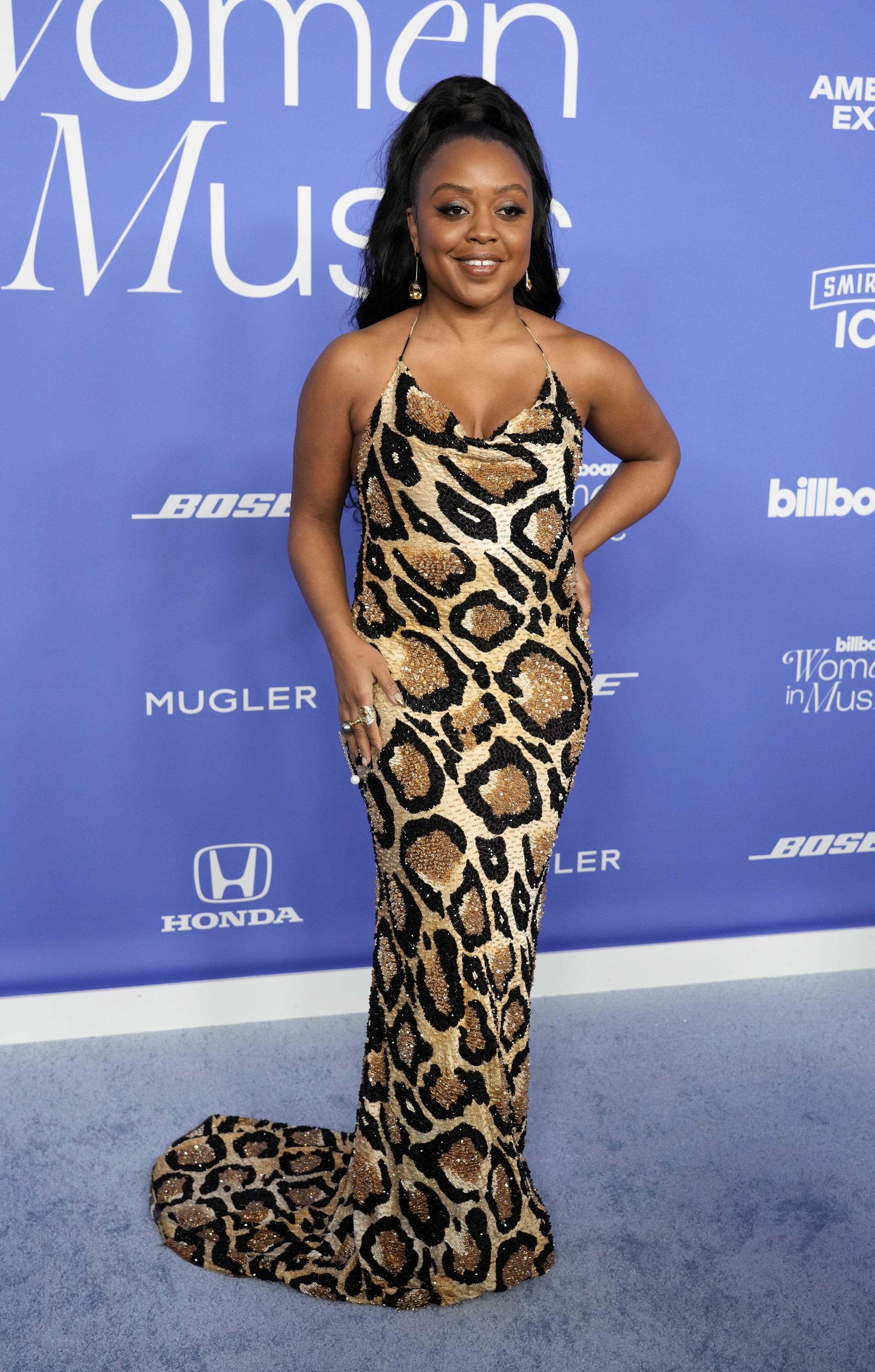 Quinta Brunson wearing a strappy sequined floor-length leopard print gown with a high pony tail
