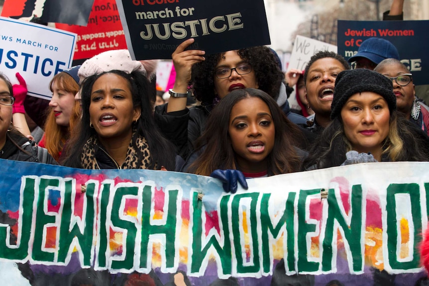 Co-President of Women's March Tamika Mallory marches with a 'Jewish women of colour' beside numerous demonstrators.