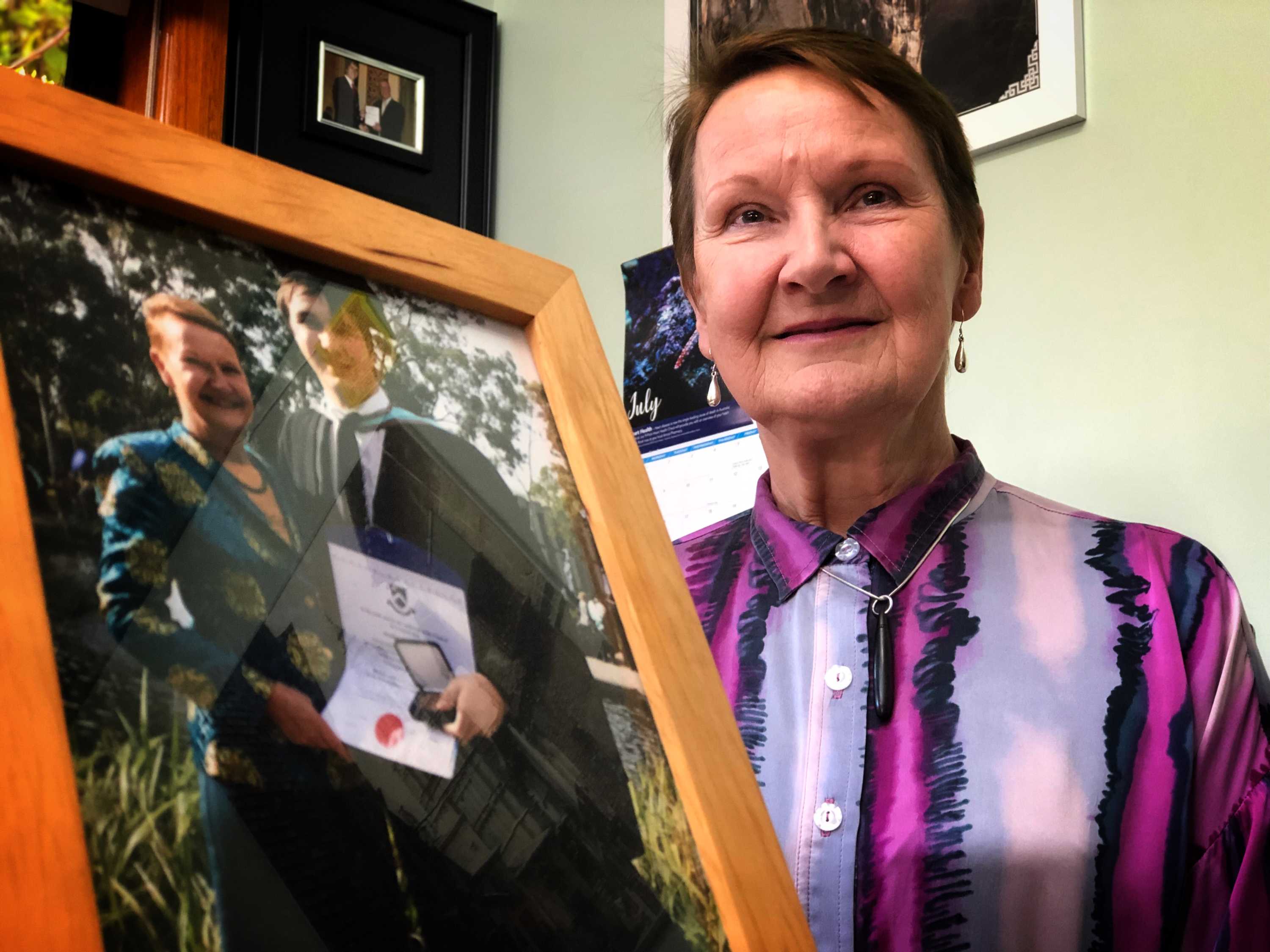 Tasmanian Association for the Gifted president Lynne Maher holding a photo of her son.