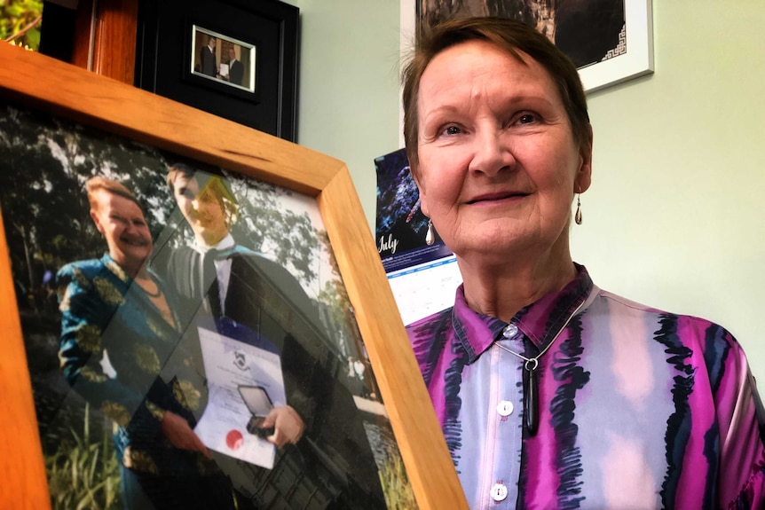 Tasmanian Association for the Gifted president Lynne Maher holding a photo of her son.