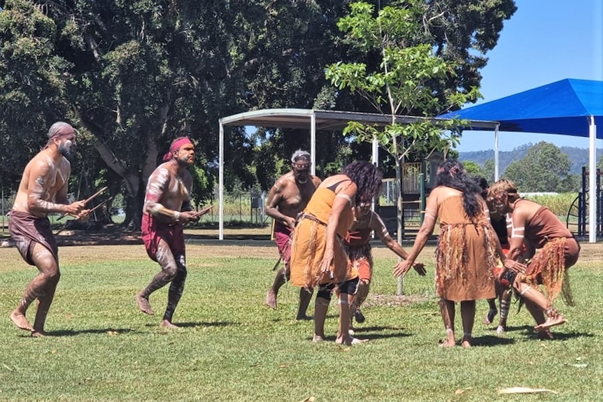 First Nations Peoples performing a traditional dance on a school oval