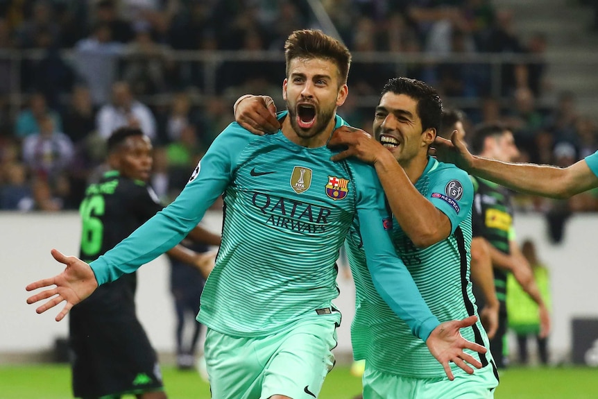 Barcelona's Gerard Pique and Luis Suarez celebrate a goal for Barcelona.