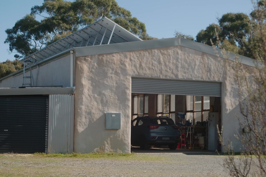 Una casa rural con paneles solares en el techo.