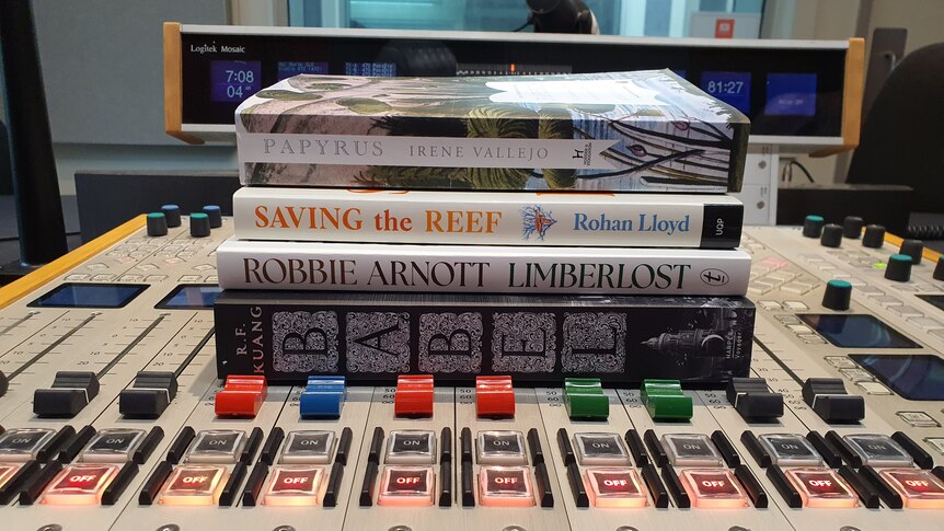 four books sitting on top of a radio console