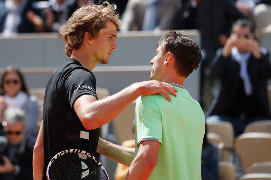 Two tennis players shake hands at the net after their French Open match.