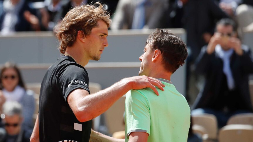 Two tennis players shake hands at the net after their French Open match.