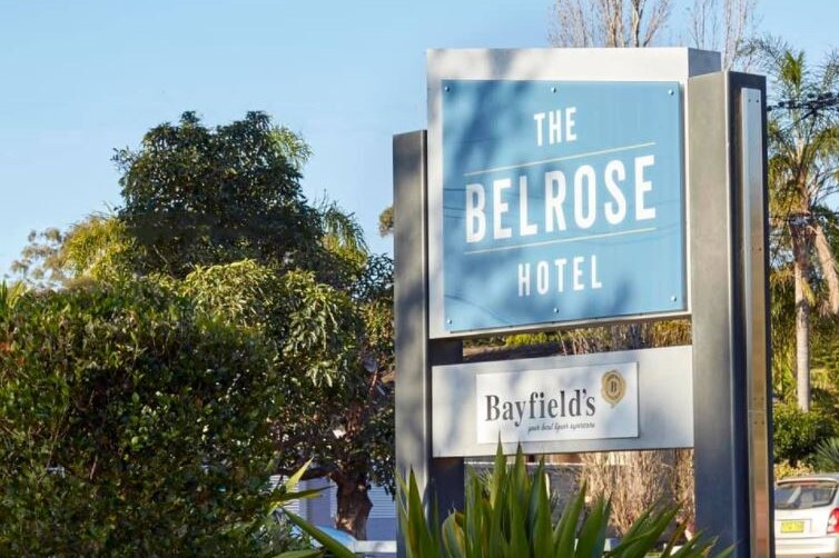 A blue and white sign that says: "The Belrose Hotel".