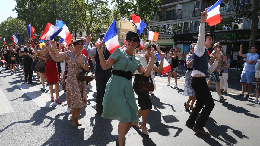 People dressed in World War II era clothes dance celebrating anniversary of the liberation of Paris.