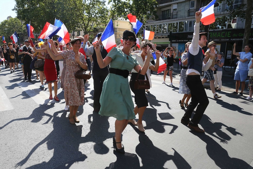 People dressed in World War II era clothes dance celebrating anniversary of the liberation of Paris.