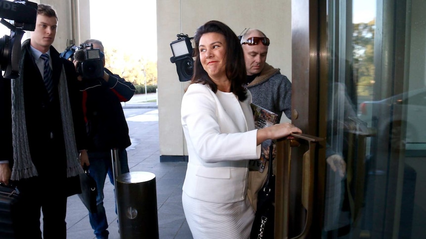 Liberal Senator Jane Hume smiles for cameras as she arrives at Parliament House for Senate School.