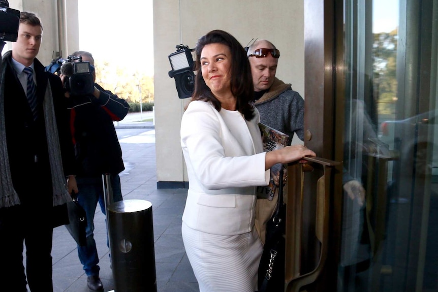 Liberal Senator Jane Hume smiles for cameras as she arrives at Parliament House for Senate School.