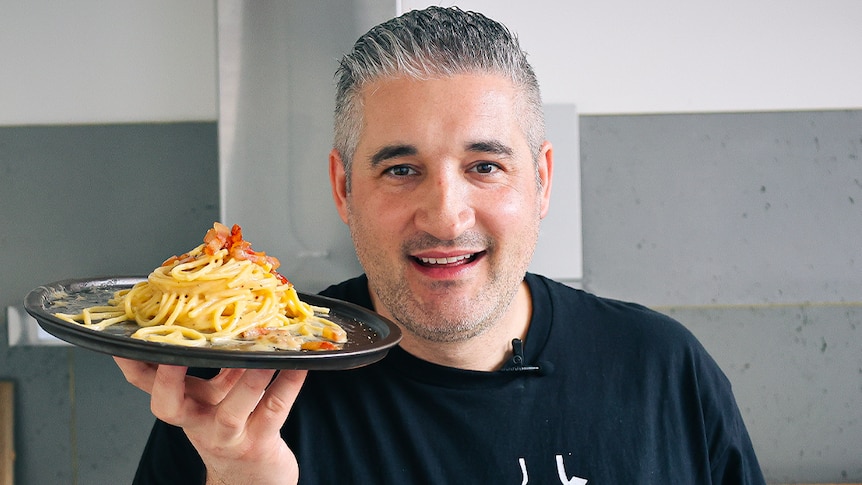Vincenzo Prosperi holding a plate of carbonara pasta. 