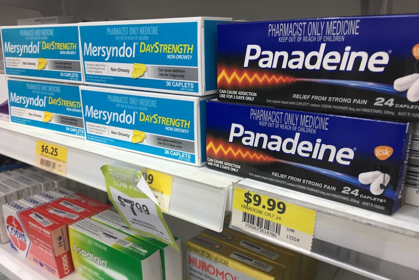 A close-up shot of drugs sitting on the shelf of a pharmacy.