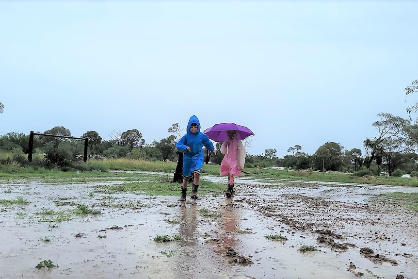 Two children play in muddy ground