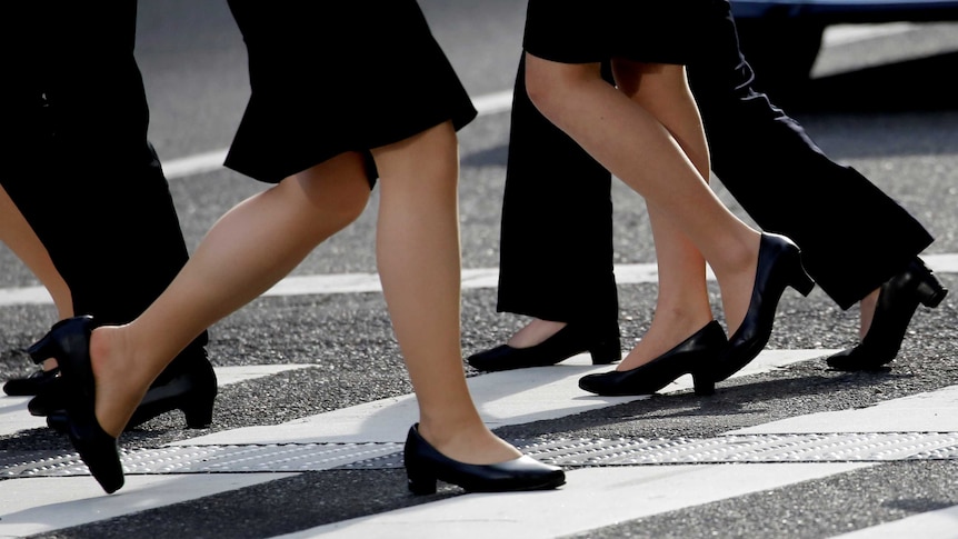 Women in high heels walk at a business district in Tokyo, Japan, June 4, 2019.