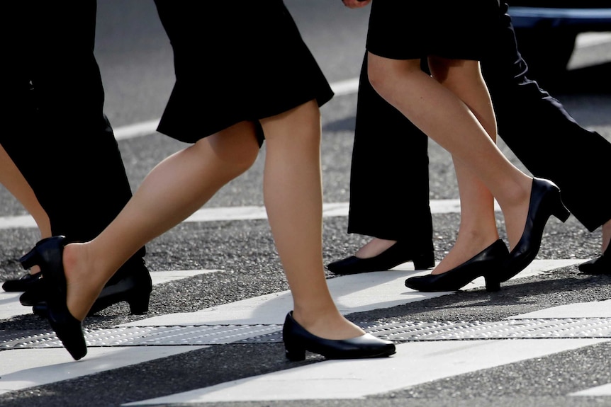 Women in high heels walk through a business district in Tokyo, Japan, June 4, 2019.