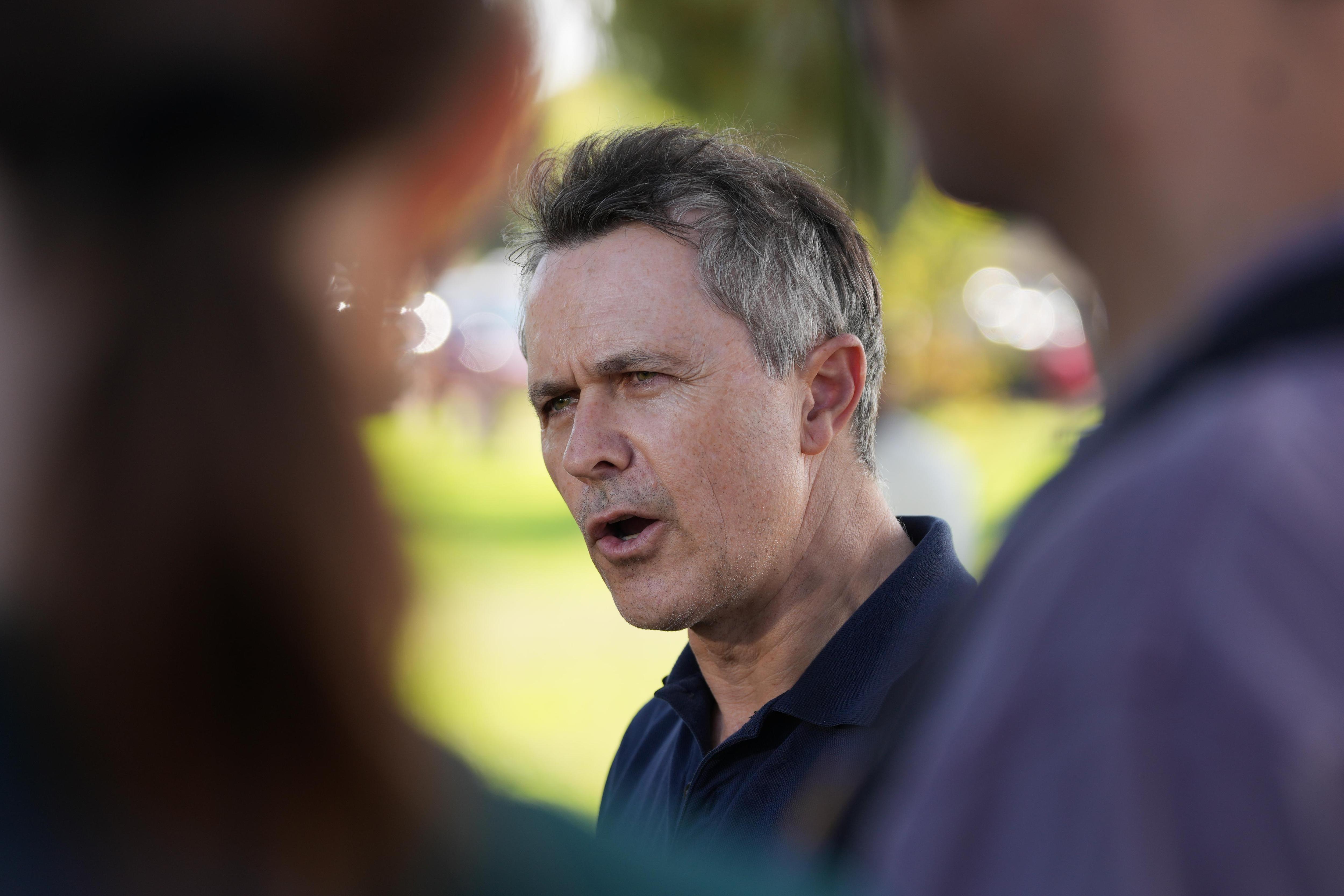 Jason Clare visto entre duas pessoas. 