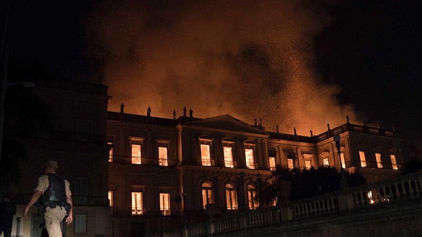 The museum is seen burning  as fire sends plumes of smoke into the air.