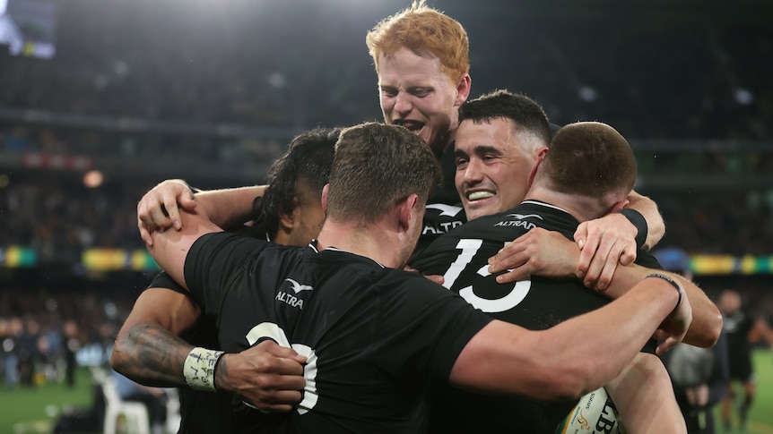 All Blacks players embrace after scoring winning try in Bledisloe Cup Test.