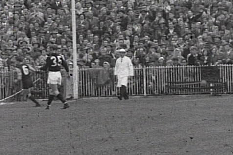 A black and white photo of an umpire at the MCG during the 1957 grand final