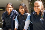 Three students sitting together in a row.