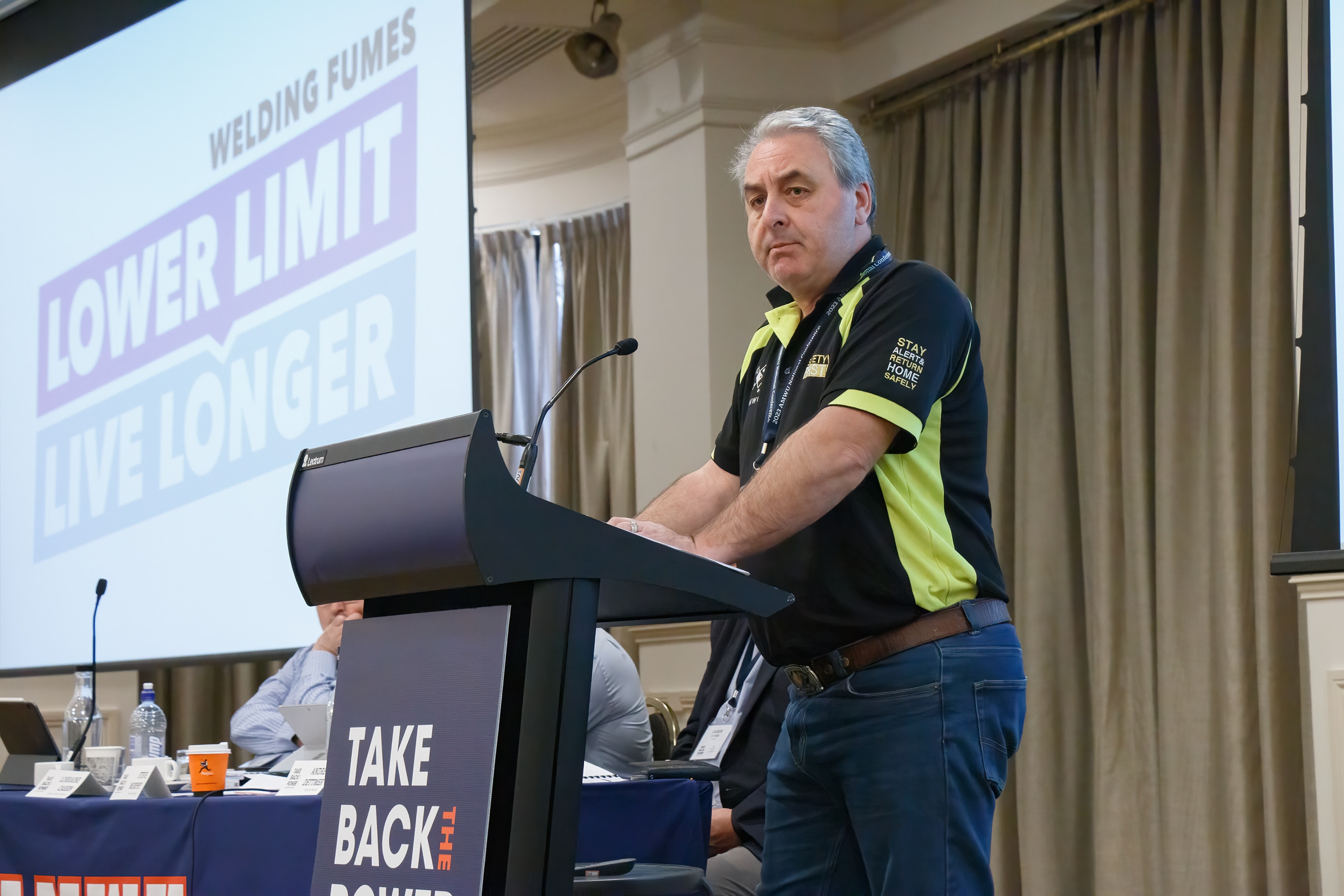 A man in a blue shirt smiling at the camera.