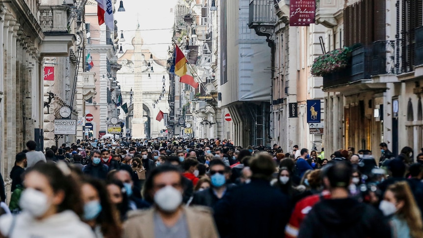 a crowd of people in a street in Rome during the day wearing face masks
