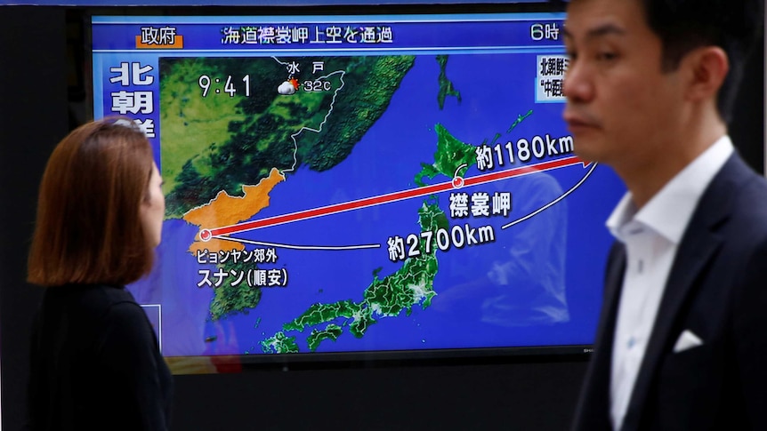 A graphic shows the distance and altitude the missile travelled over a map of korea and japan
