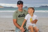 Michael Noakes sitting on Middleton Beach, Albany with 7 year old son Lucas