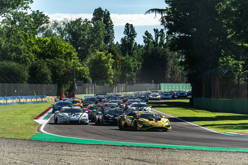 Lamborghini cars take the first turn of the Imola race track. 