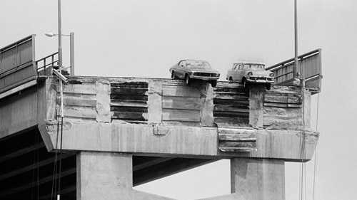 Black and white image of cars hanging over Hobart's Tasman Bridge in 1975 after a section was knocked down by a ship