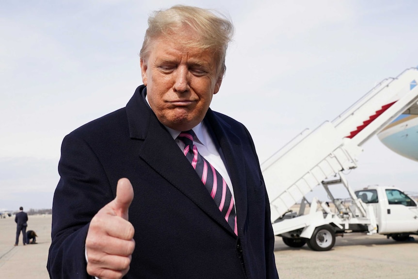 Donald Trump giving the thumbs up with Air Force One in the background