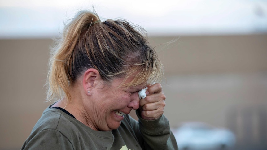 A woman cries while speaking to police outside a Walmart store.