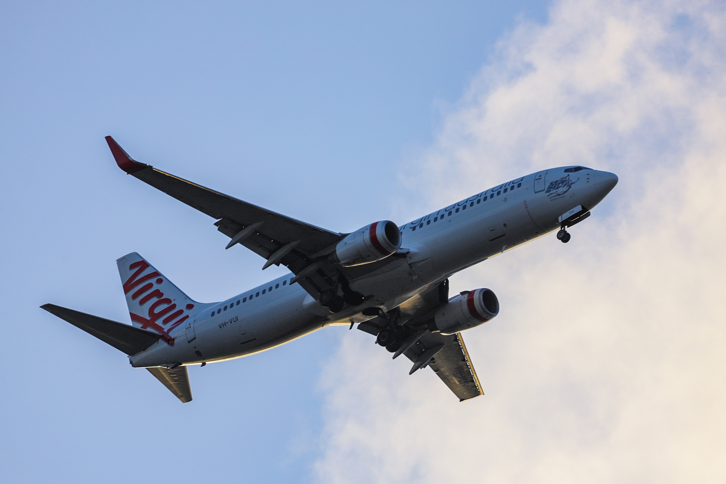 A Virgin plane flying in the sky in Brisbane.
