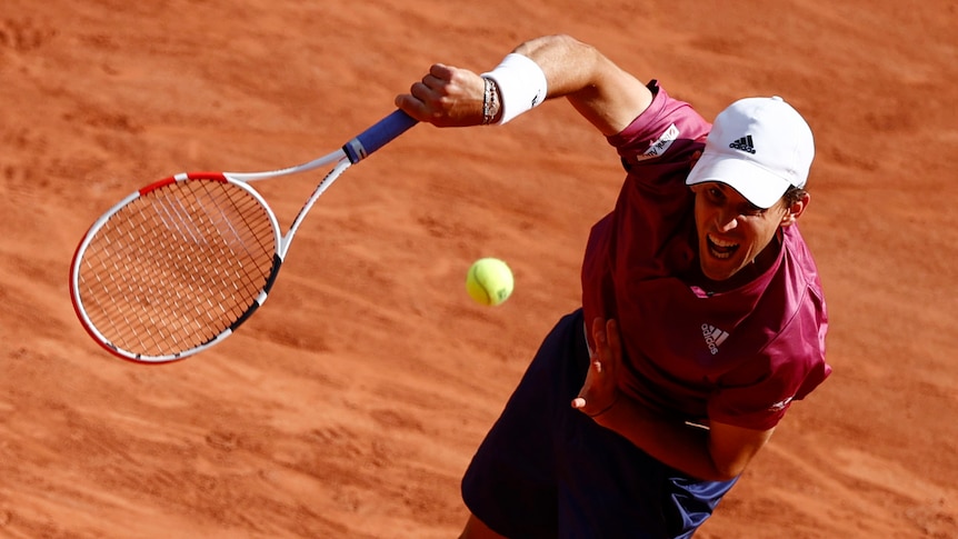 Dominic Thiem serving on a clay court.