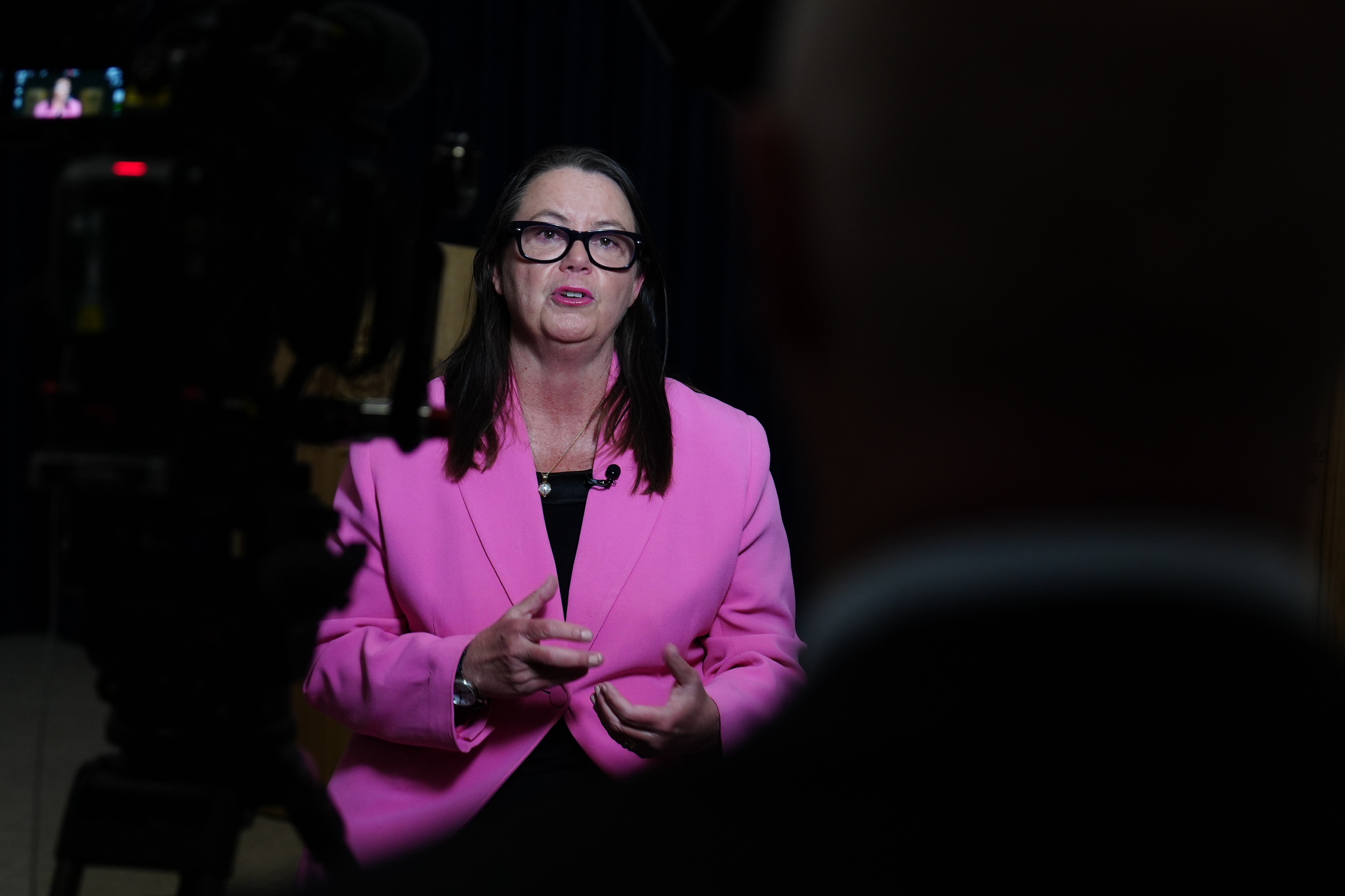 A photo of Madeleine King in a pink blazer gesticulating