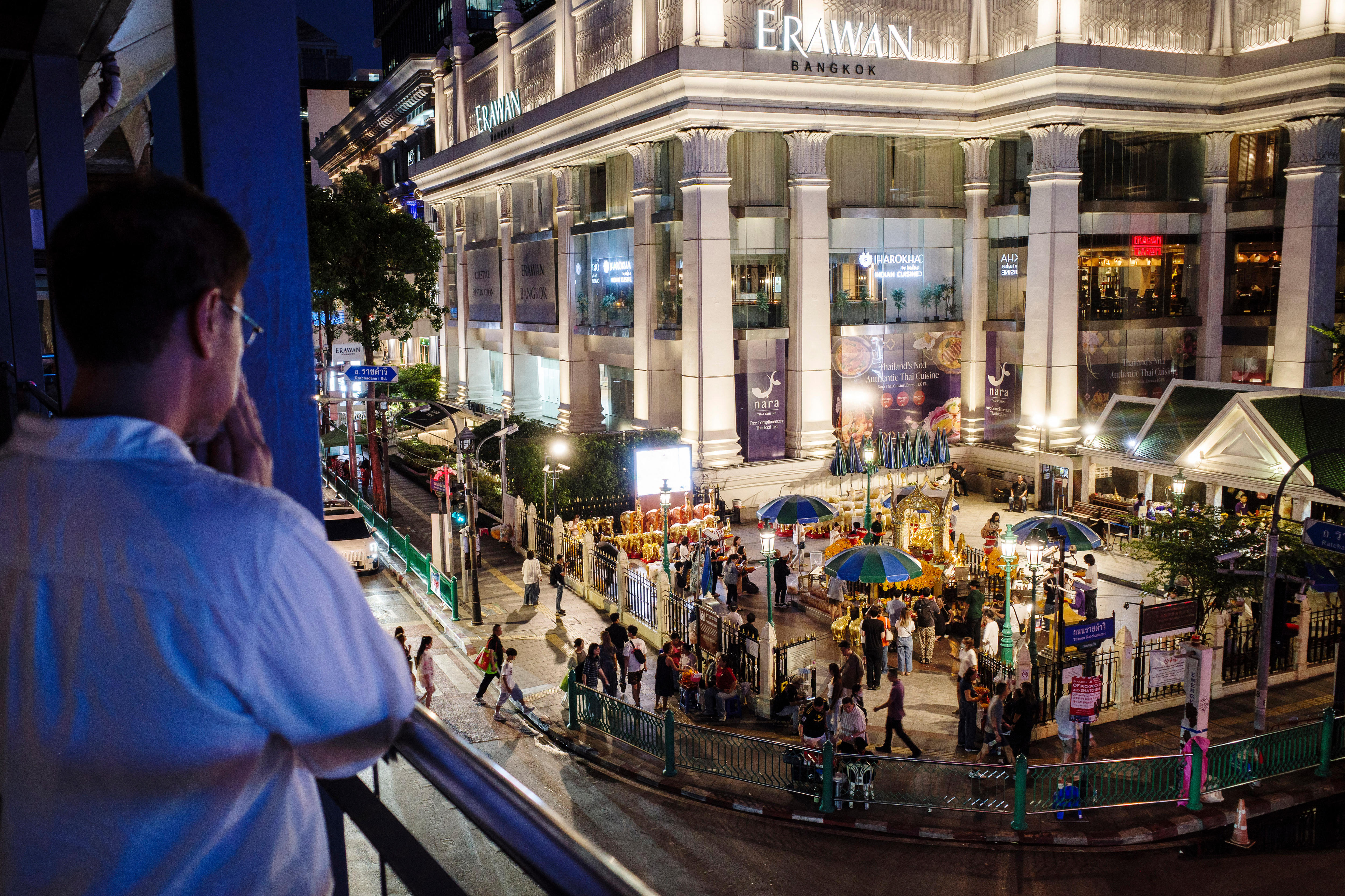 A man prays as he faces a Thai temple