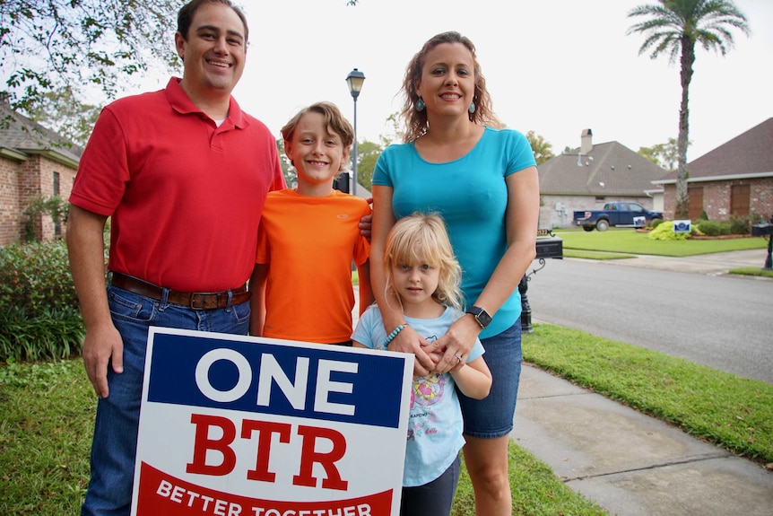 A family smile with a campaign sign