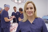 Heart surgeon Nikki Stamp stands in a operating room.
