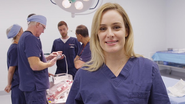 Heart surgeon Nikki Stamp stands in a operating room.