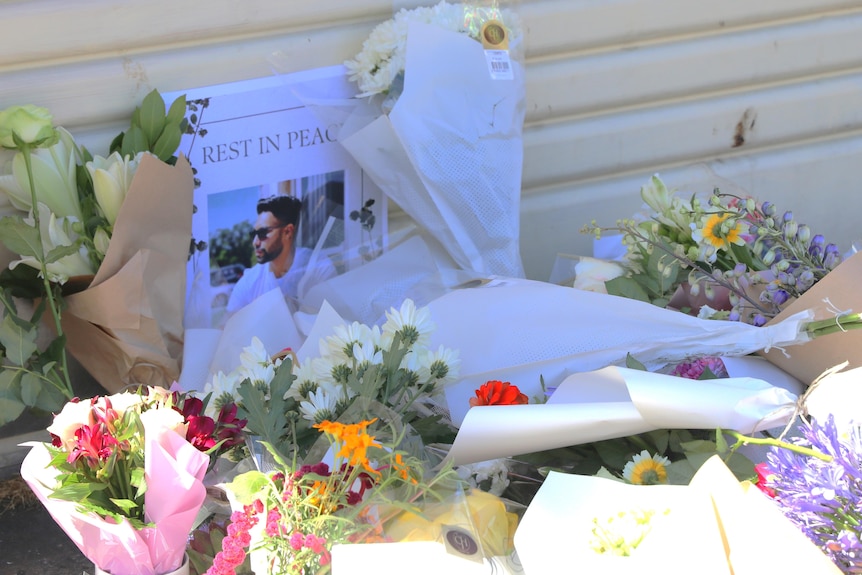 Floral tributes for a deceased man.